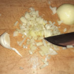 Zwiebeln würfeln und Knoblauch hacken