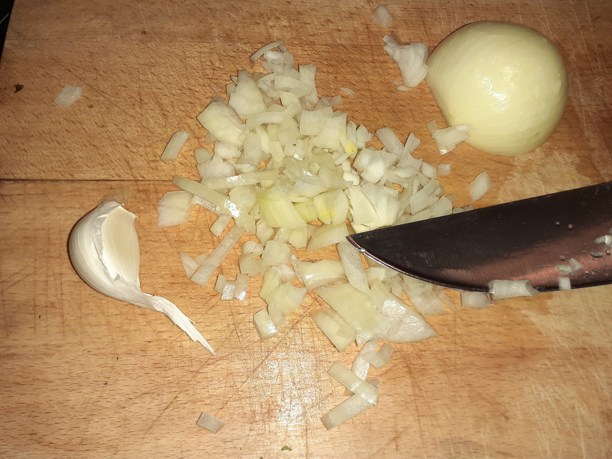 Zwiebeln würfeln und Knoblauch hacken